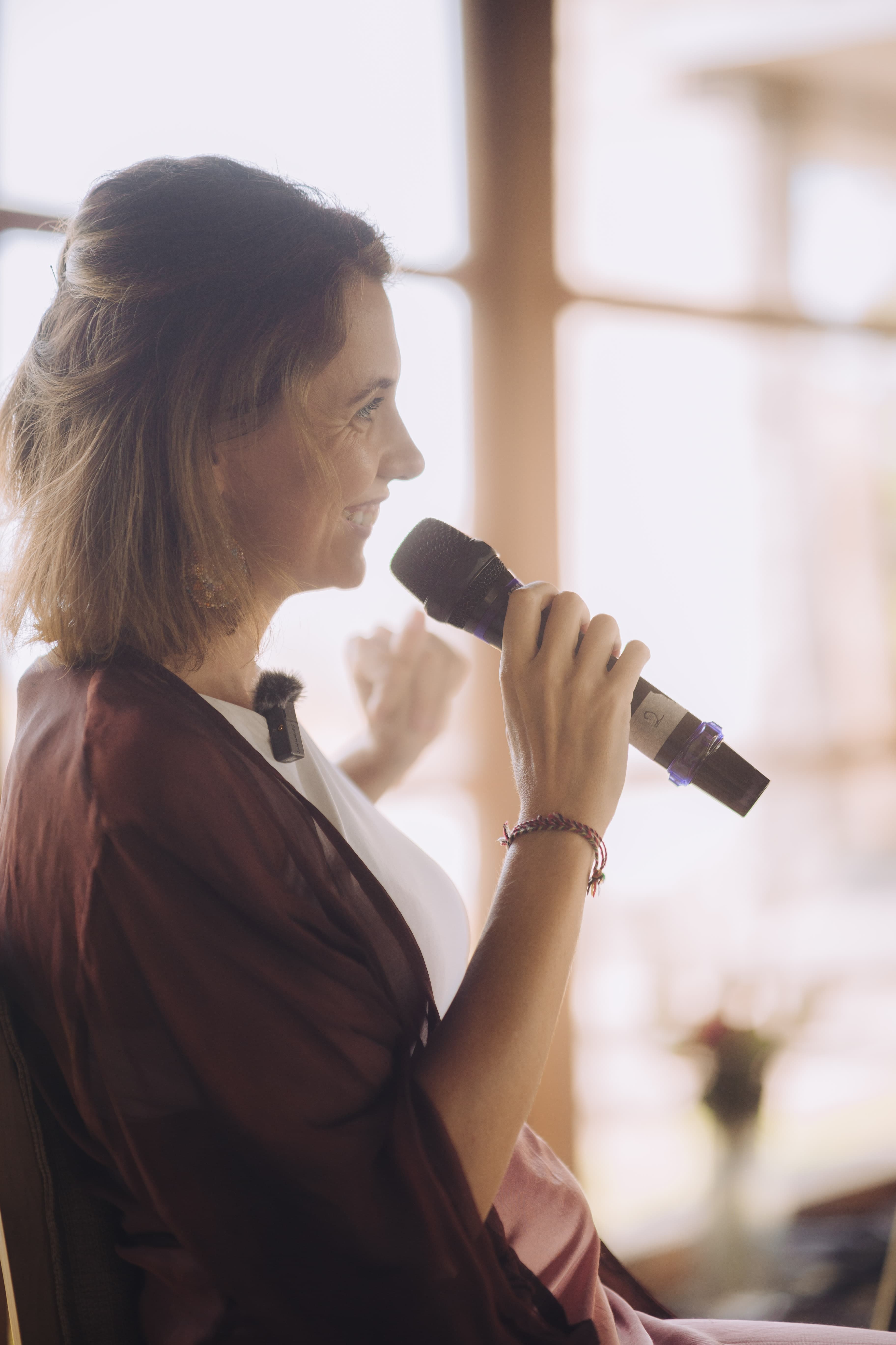 Close profile of Kirsty speaking into a microphone