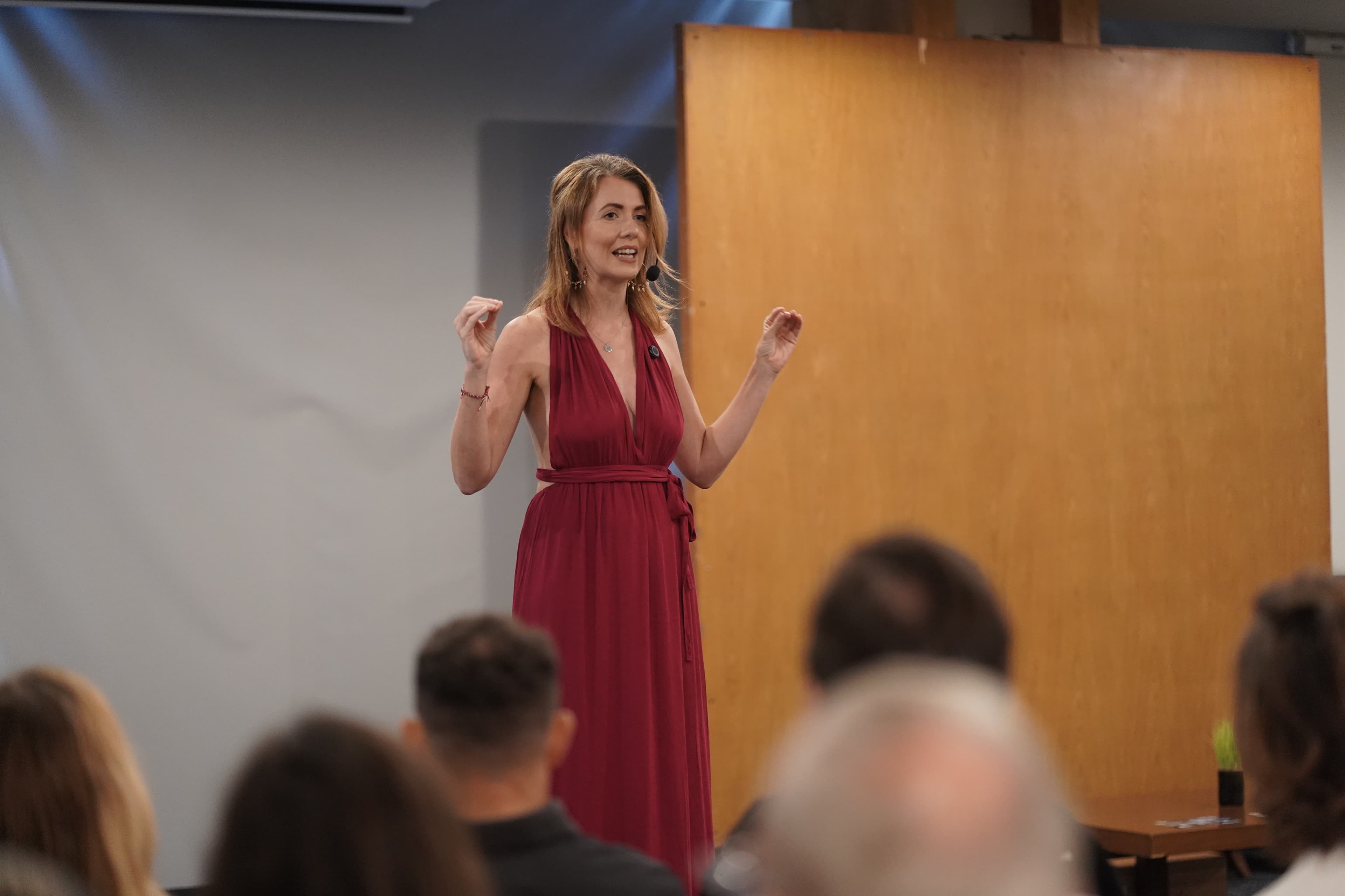 Kirsty mid-gesture, speaking with energy on stage